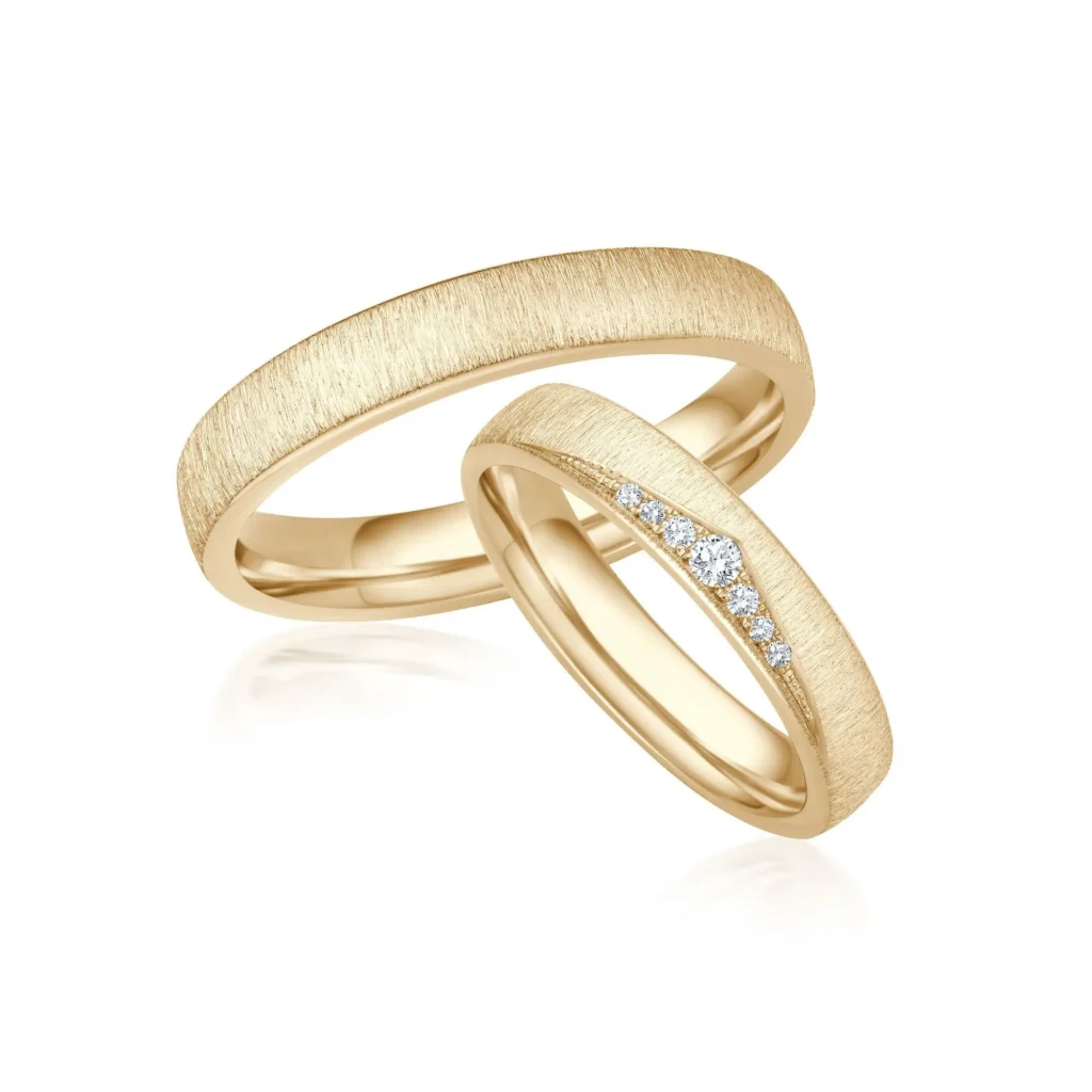 Eheringe in Gelbgold mit grober Quermatt-Oberfläche, Damenring mit sieben Brillanten, Ringpaar